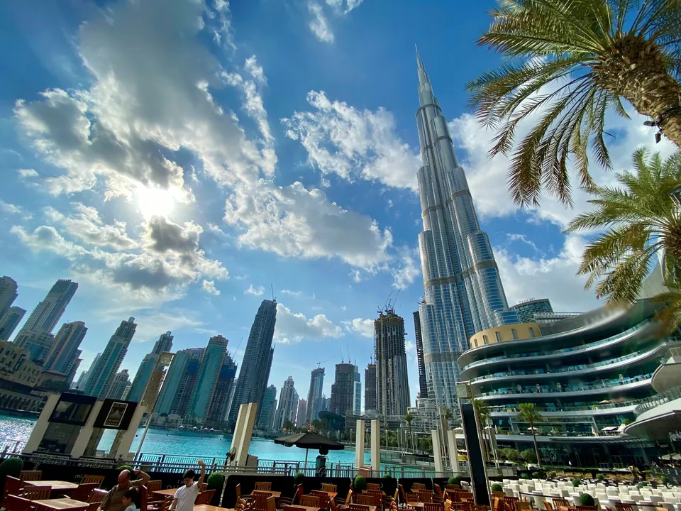 Dubai skyscrapers and palm trees beneath a cloudy sky