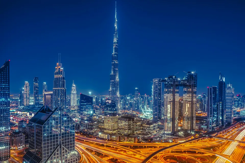 Illuminated Dubai skyline and highways at night