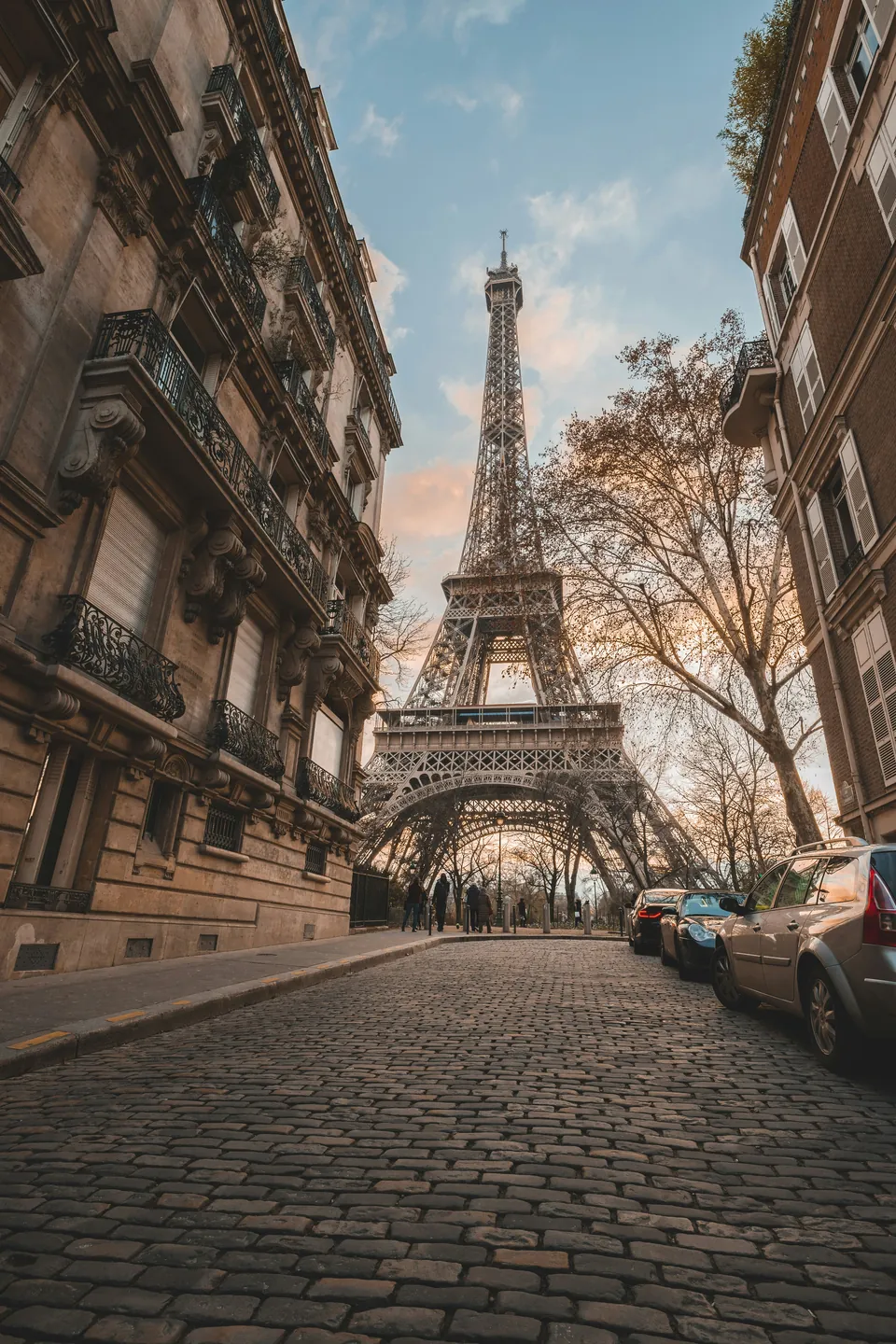 Paris street lined with buildings and a view of the Eiffel Tower