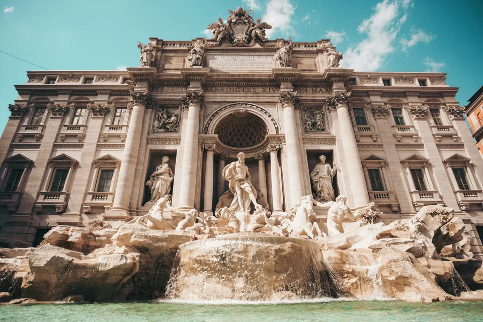 Ornate fountain and statues in front of an Italian building