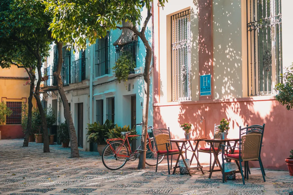 Outdoor cafe tables and a bicycle on a colorful street