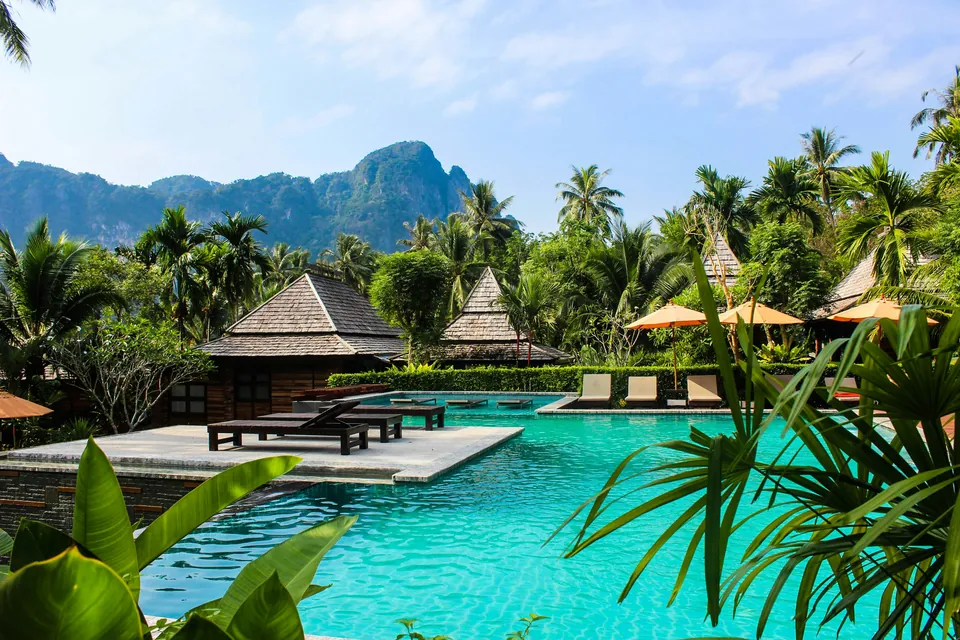 Swimming pool surrounded by tropical gardens and Thai-style buildings