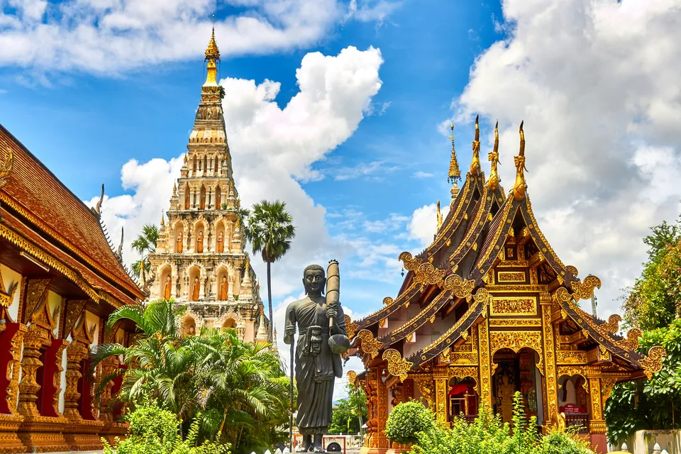 Ornate Thai temple buildings beneath a blue sky