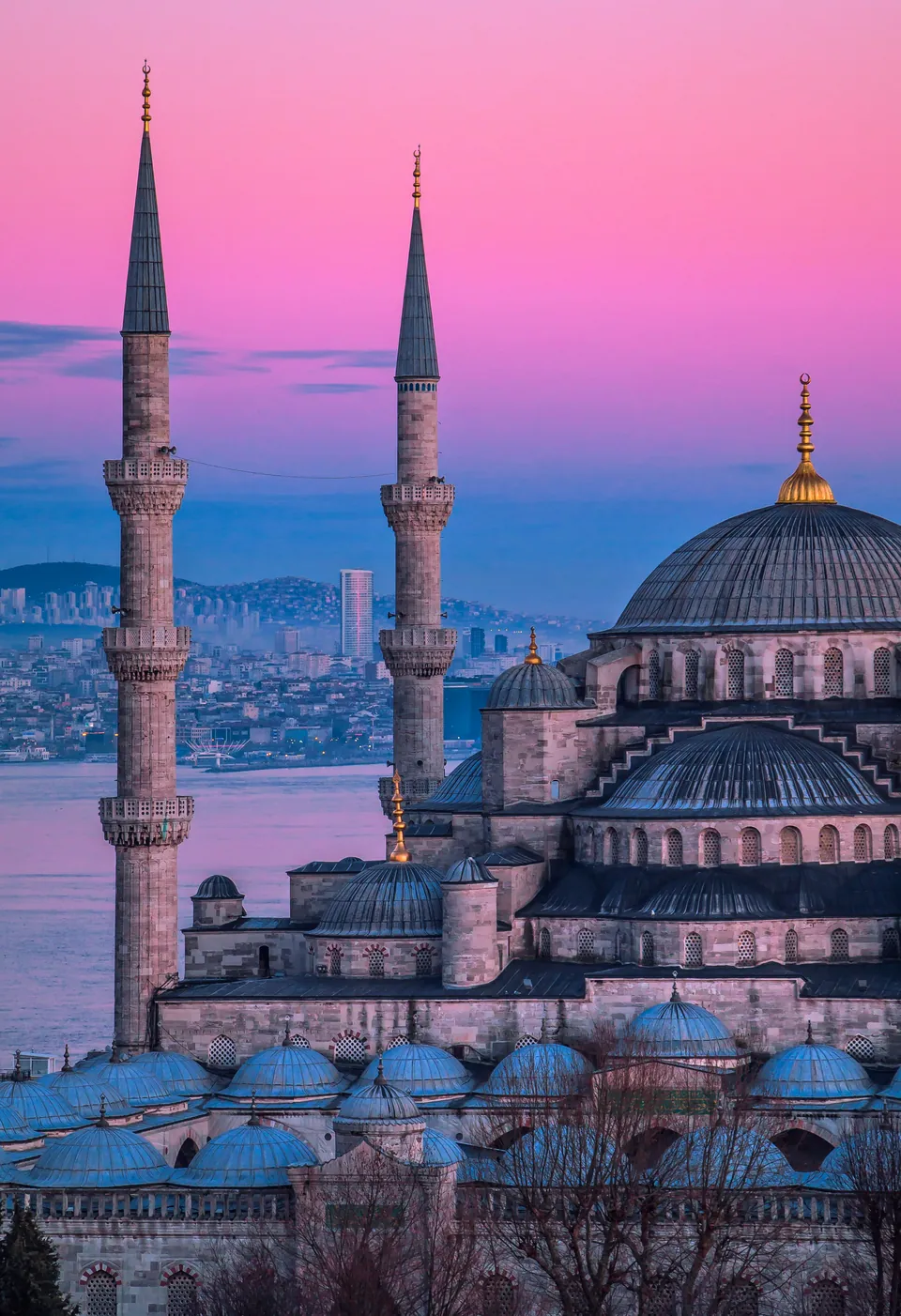 Mosque domes and minarets against a colorful evening sky
